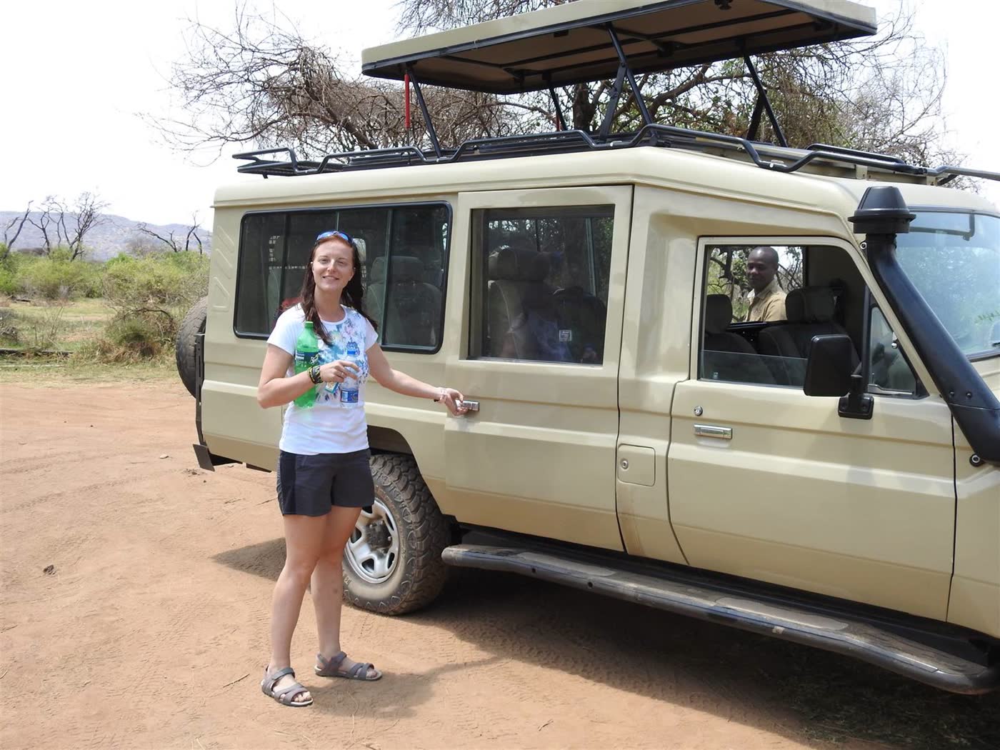 NGULI guest and driver beside a safari Land Cruiser