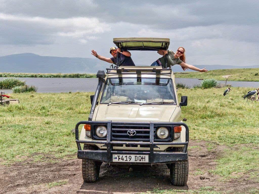 NGULI guests celebrating from their safari vehicle roof hatch
